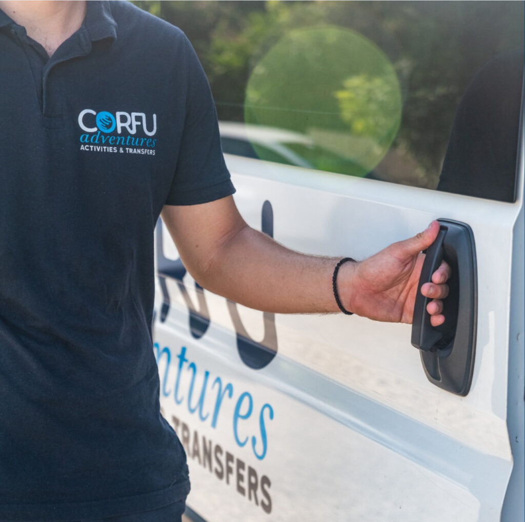 Corfu Adventures driver in a branded polo shirt opening the sliding door of a transfer van